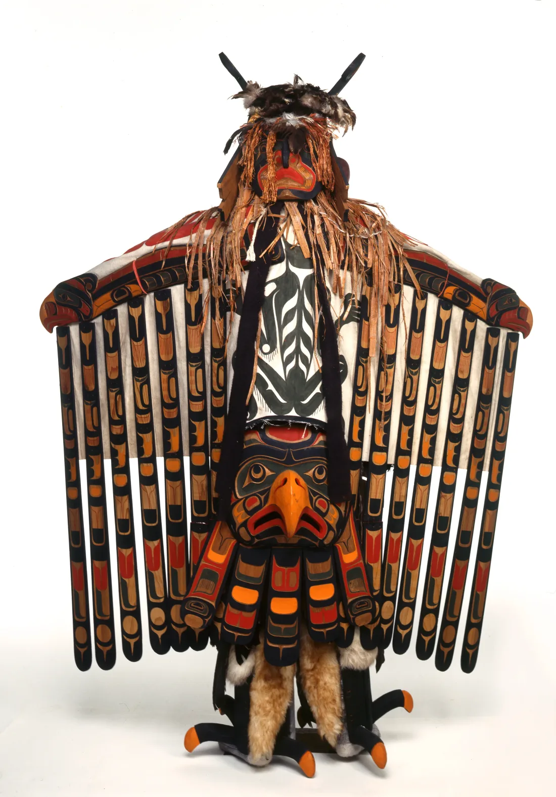 Costume and mask representing a thunderbird, arms spread, colourful