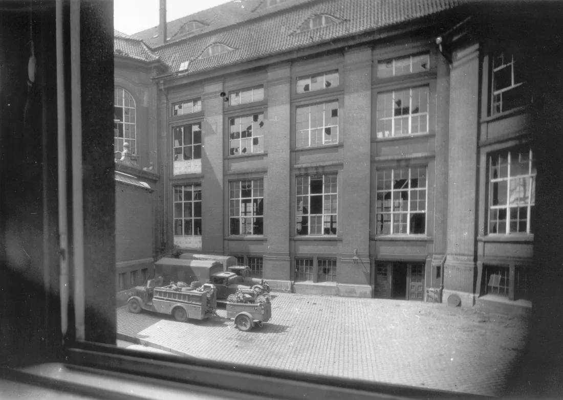 Innenhof, Gebäude, zerstörte Fenster, Militärfahrzeuge, Blick aus dem Fenster, s/w Fotografie