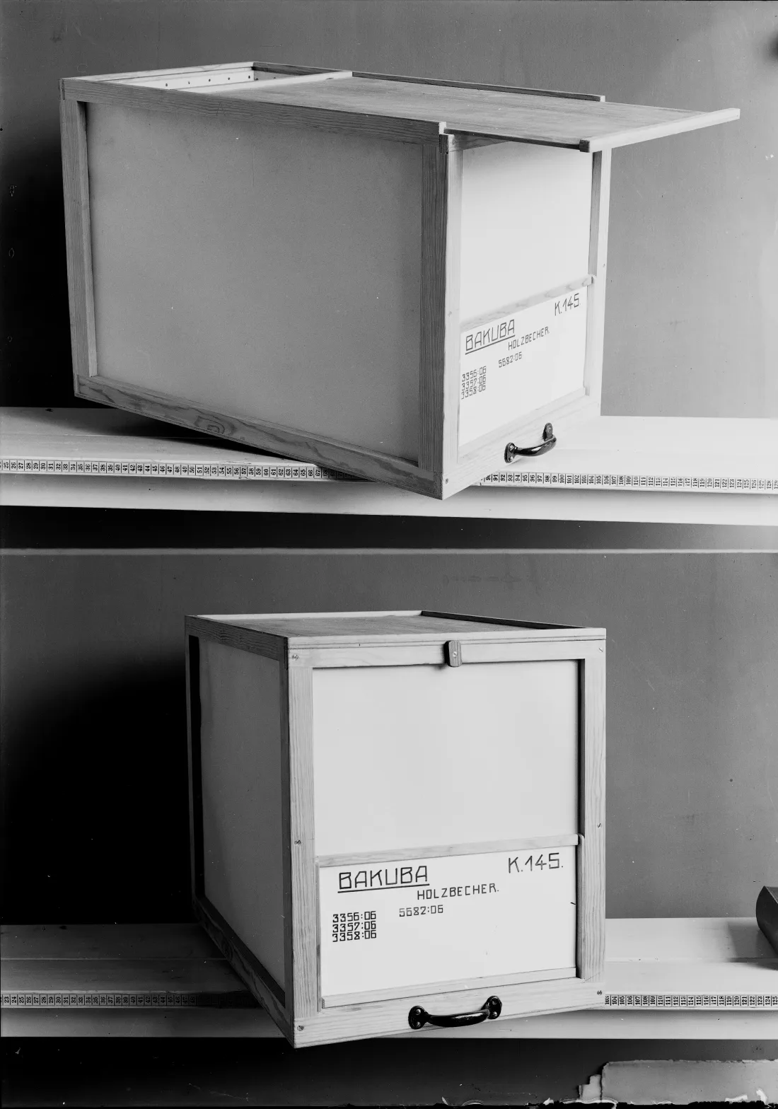 Zwei Regalborde, zwei Holzkisten mit Beschriftung, s/w Fotografie
