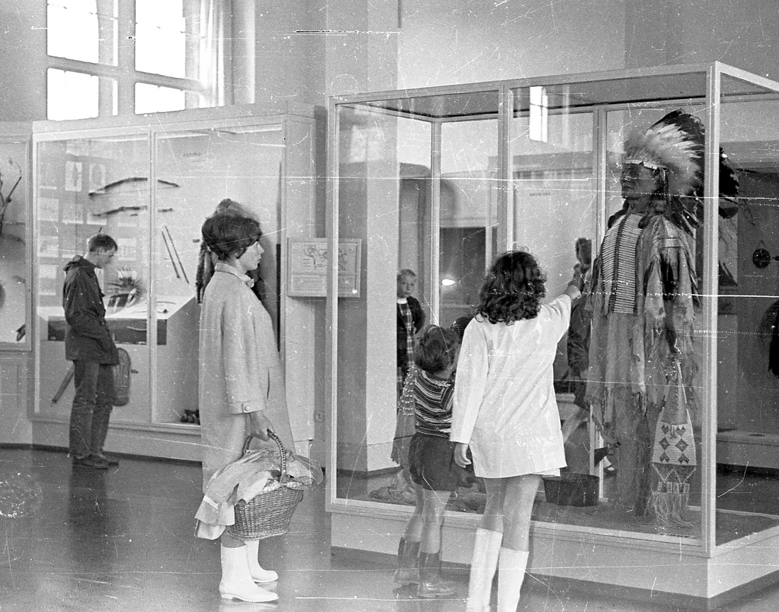 Ausstellungsvitrinen, Figur mit Bekleidung, Besucher*innen, Gummistiefel, s/w Fotografie