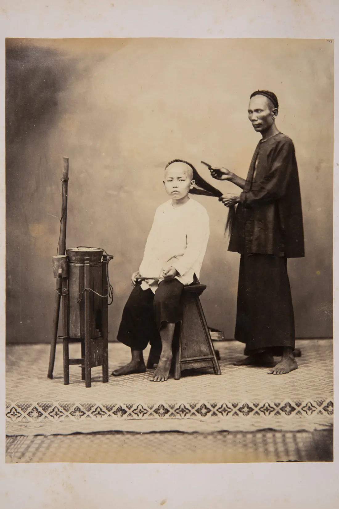 Album with studio portraits, city views and landscape photographs from Singapore, 1868